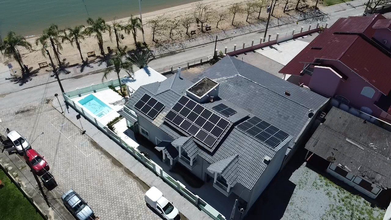 Vista aérea do Projeto 04 — residência beira-mar com 18 módulos fotovoltaicos de 550W