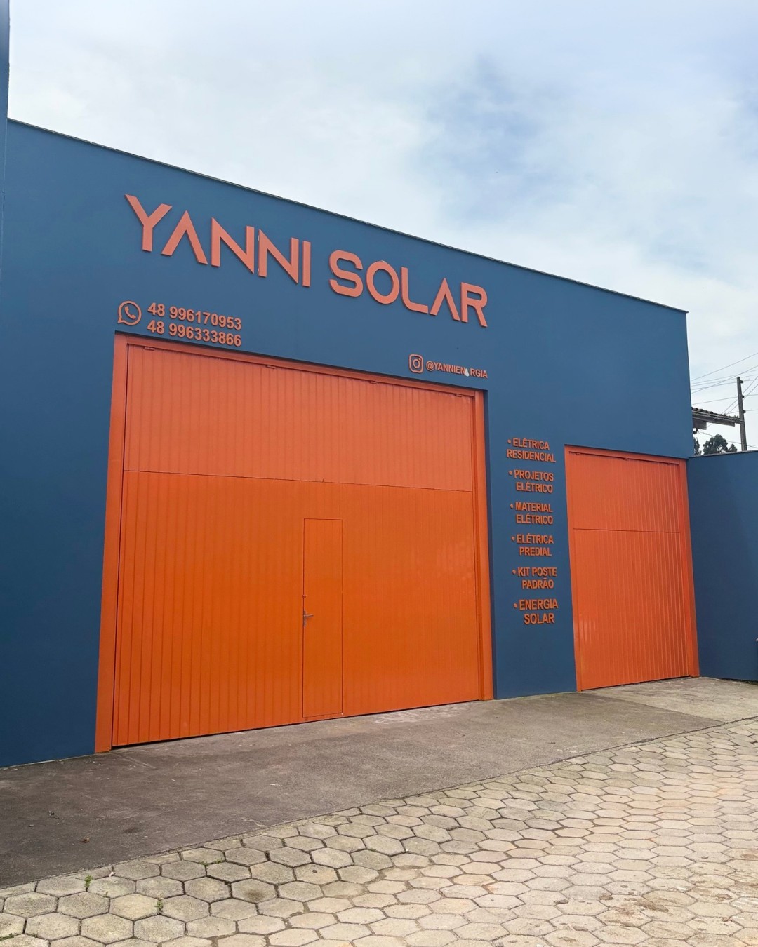 Fachada da Unidade 1 — Matriz Yanni Solar em Paulo Lopes, com portões laranja e comunicação visual da marca