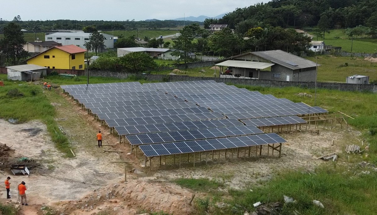Vista aérea da usina solar do Posto Maciambu, instalada sobre estrutura de madeira em campo aberto